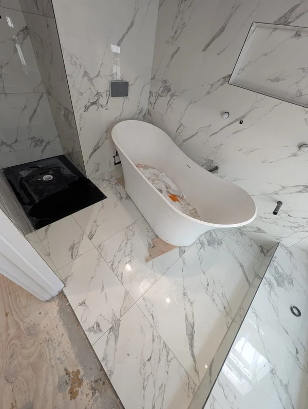 Calacatta bathroom — Book-matched porcelain, freestanding bath