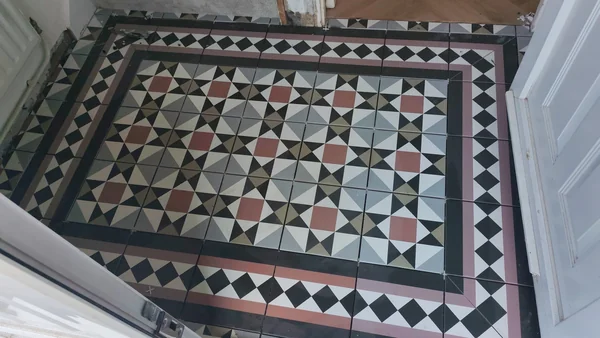Geometric hall floor — Restored border in red, black and buff